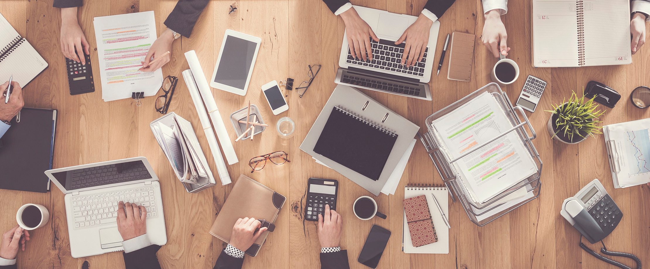 Konferenztisch mit Notebooks, Taschenrechner, Handy, Telefon, Papier