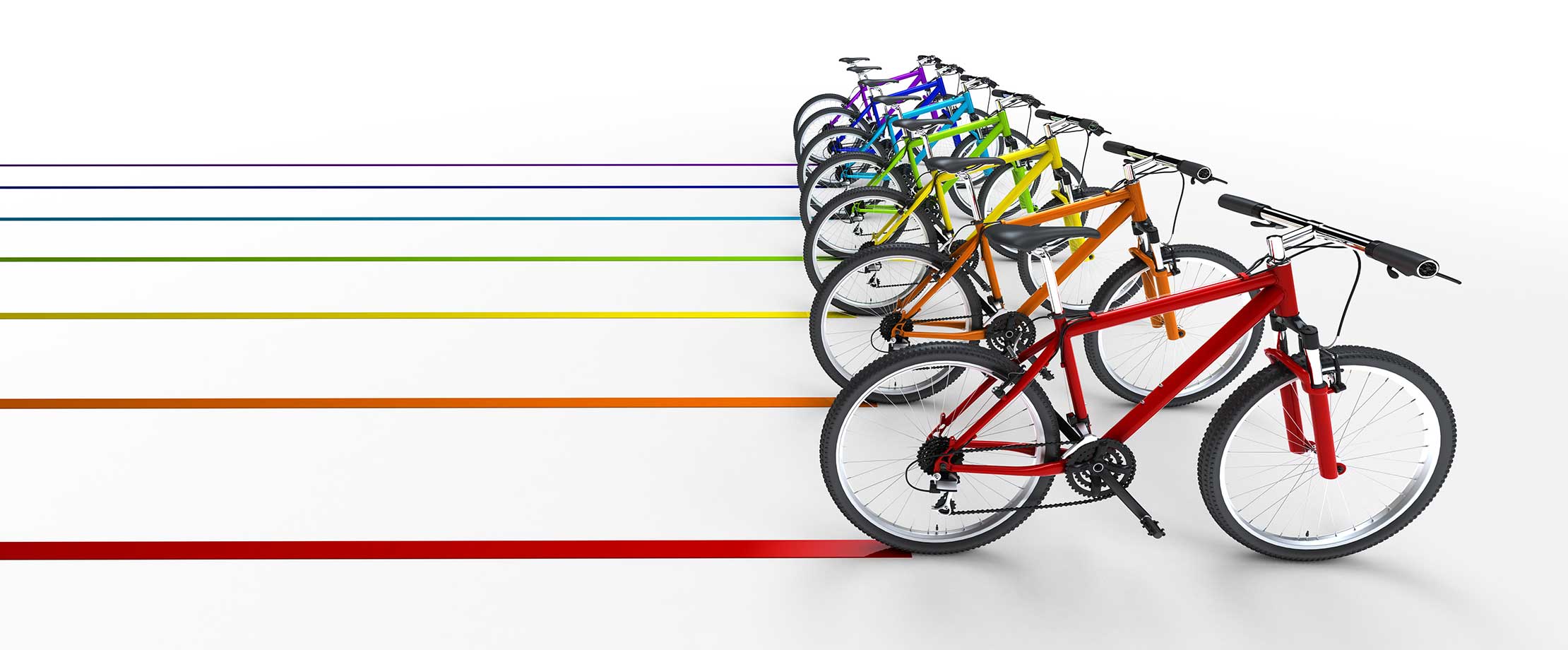 Bunte Fahrräder fahren vor einem weißen Hintergrund und ziehen Spuren in der gleichen Farbe nach sich.